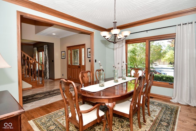 dining area with a chandelier, light hardwood / wood-style floors, and crown molding