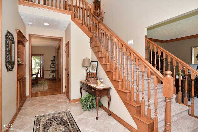 staircase featuring ornamental molding and tile patterned floors