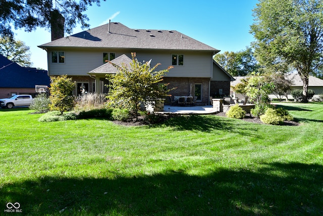 rear view of property featuring a yard and a patio area