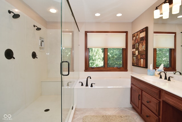 bathroom featuring independent shower and bath, vanity, and tile patterned flooring