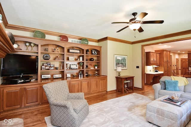 living room with light wood-type flooring, ornamental molding, and ceiling fan