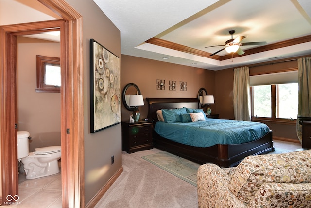 bedroom with a raised ceiling, multiple windows, light colored carpet, and ceiling fan