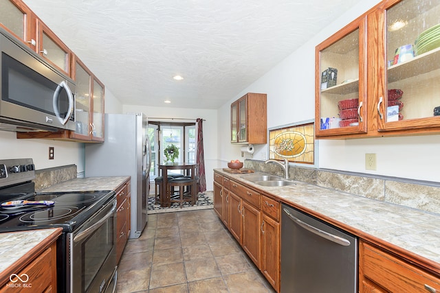 kitchen with a textured ceiling, appliances with stainless steel finishes, and sink