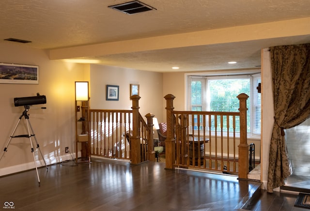 interior space with a textured ceiling and dark hardwood / wood-style floors