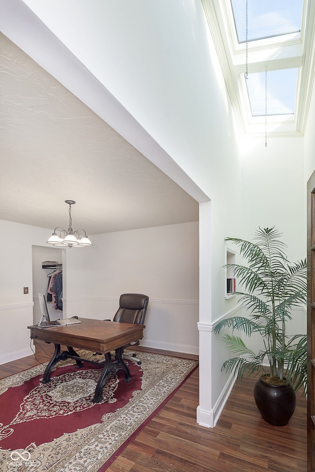 home office featuring dark hardwood / wood-style floors and a skylight