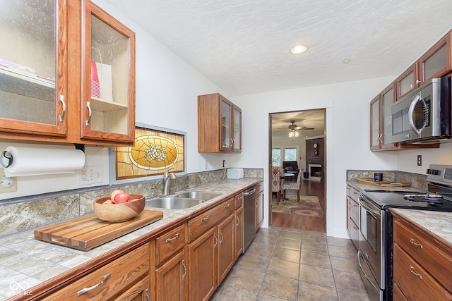 kitchen with a textured ceiling, light hardwood / wood-style floors, sink, appliances with stainless steel finishes, and ceiling fan