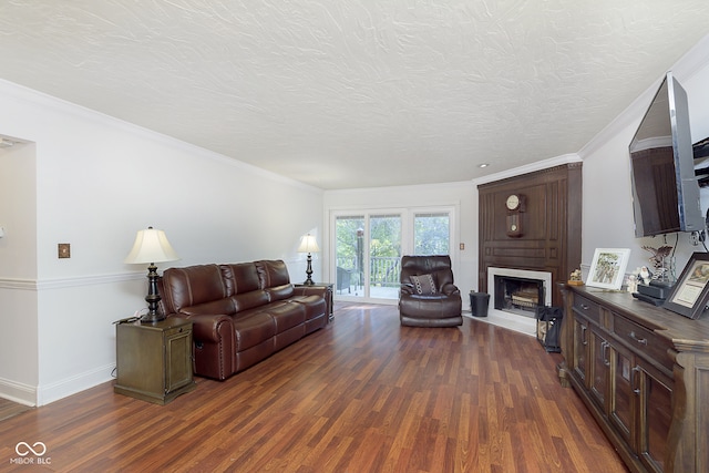 living room with a textured ceiling, dark hardwood / wood-style floors, and ornamental molding