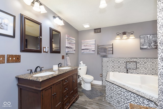 bathroom featuring vanity, hardwood / wood-style floors, a tub, and toilet