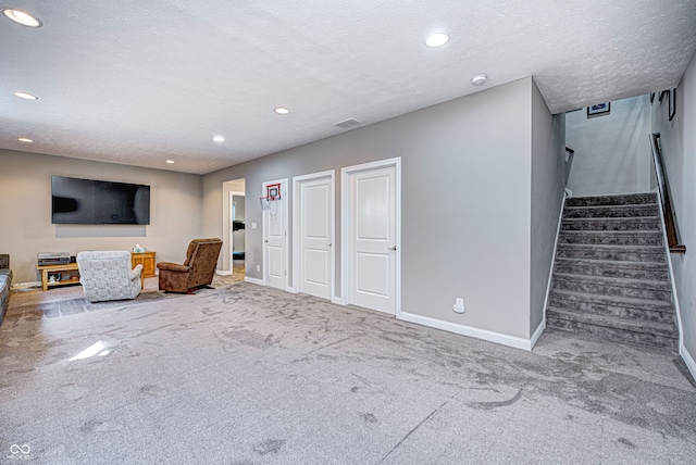 unfurnished room with carpet and a textured ceiling