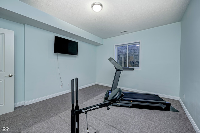 workout area with carpet floors and a textured ceiling