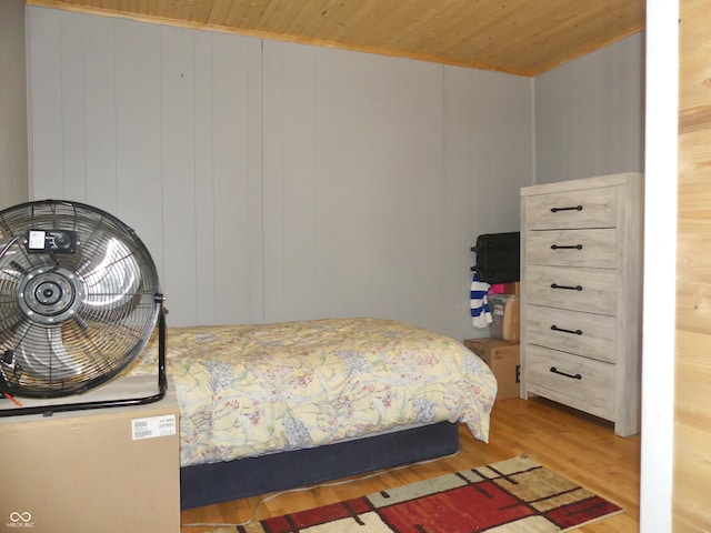 bedroom with wood ceiling, wood walls, and hardwood / wood-style flooring