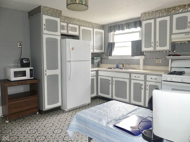 kitchen with premium range hood, white appliances, and sink