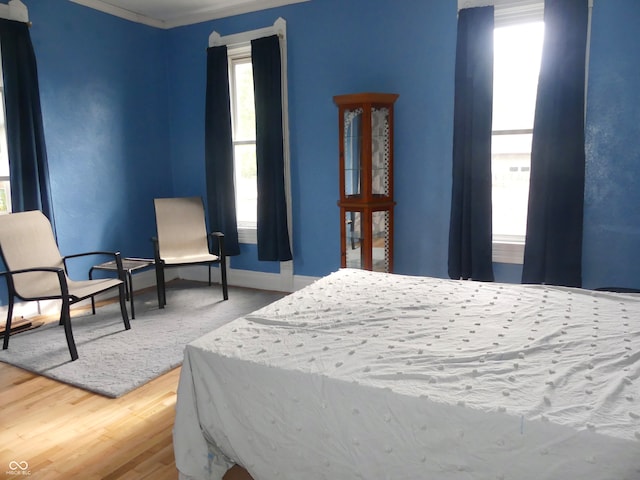 bedroom with ornamental molding and hardwood / wood-style floors