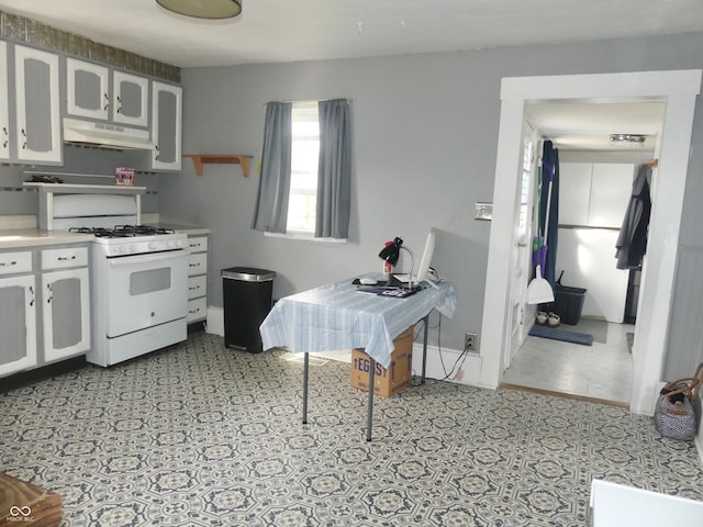 kitchen with white gas range oven and white cabinets