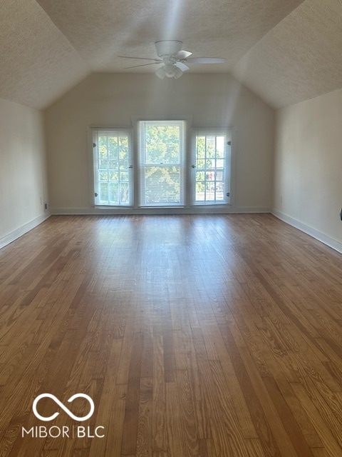 bonus room featuring lofted ceiling, ceiling fan, hardwood / wood-style flooring, and a textured ceiling