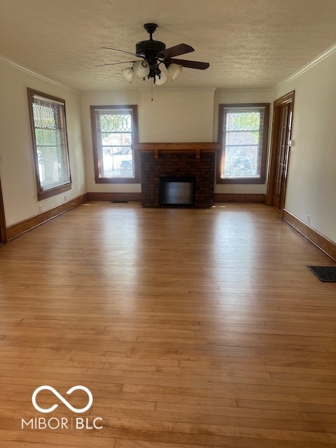 unfurnished living room featuring a brick fireplace, light hardwood / wood-style flooring, and ceiling fan