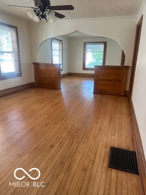 unfurnished room with light wood-type flooring, a textured ceiling, and ceiling fan