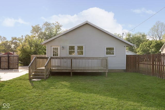 back of property with a wooden deck and a lawn