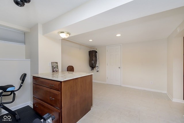 kitchen featuring light tile patterned flooring, kitchen peninsula, and light stone countertops