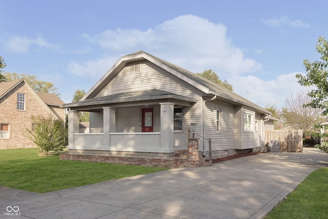 bungalow-style house with a front lawn and covered porch