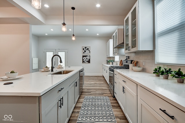 kitchen with pendant lighting, dark hardwood / wood-style flooring, appliances with stainless steel finishes, and sink