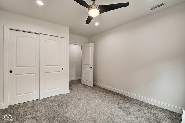 unfurnished bedroom featuring ceiling fan, light colored carpet, and a closet