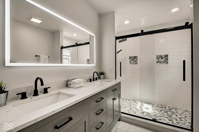 bathroom with a shower with shower door and vanity