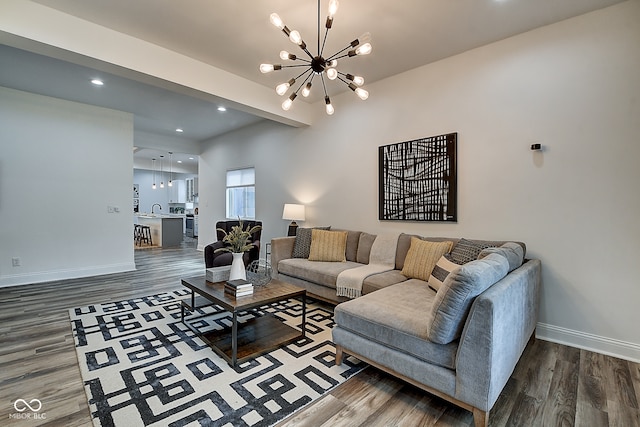 living room with sink, dark wood-type flooring, and a notable chandelier