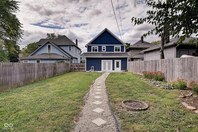 rear view of house with french doors and a yard