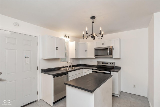 309 N Lasalle St, Indianapolis, IN 46201 - kitchen featuring dark countertops, a sink, an inviting chandelier, white cabinetry, and appliances with stainless steel finishes