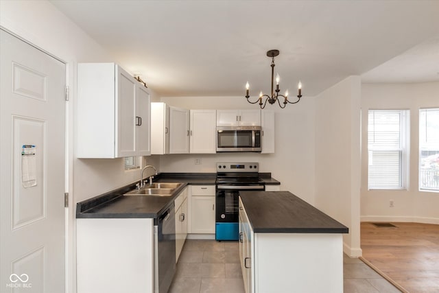 kitchen with a kitchen island, white cabinetry, sink, and stainless steel appliances