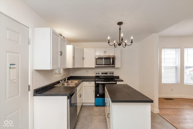 309 N Lasalle St, Indianapolis, IN 46201 - kitchen featuring dark countertops, white cabinetry, stainless steel appliances, and a sink