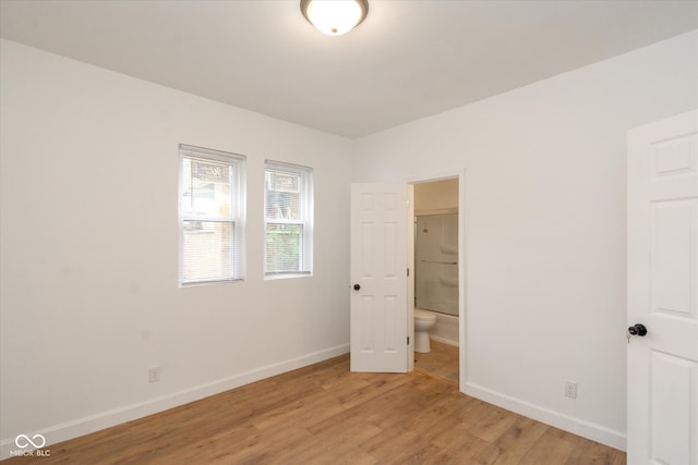 unfurnished bedroom featuring light hardwood / wood-style floors and ensuite bathroom