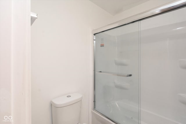 bathroom with combined bath / shower with glass door and toilet