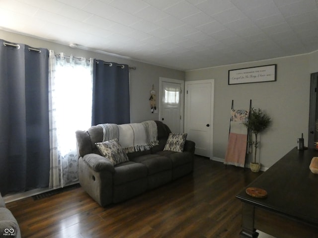 living room with ornamental molding and dark hardwood / wood-style floors