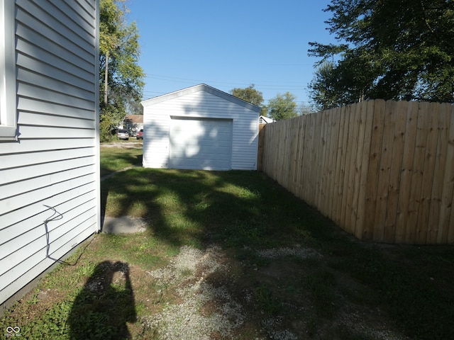 view of yard with a garage and an outbuilding