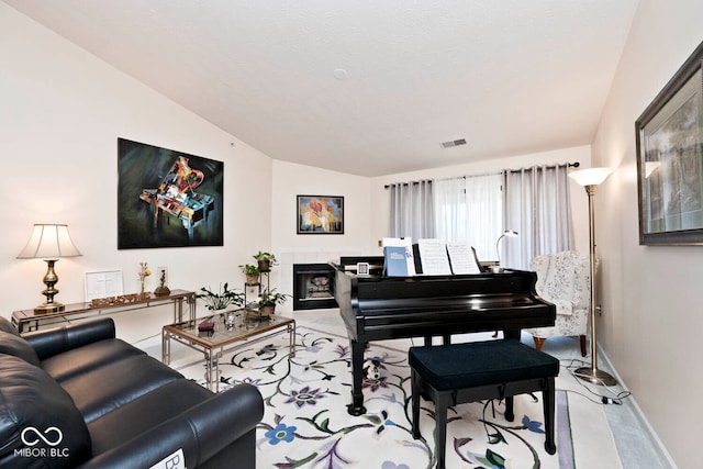 interior space featuring lofted ceiling and a tile fireplace