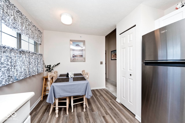 dining space with hardwood / wood-style flooring and a textured ceiling