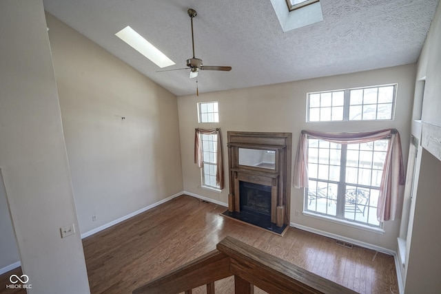 unfurnished living room featuring hardwood / wood-style floors, a textured ceiling, high vaulted ceiling, and ceiling fan