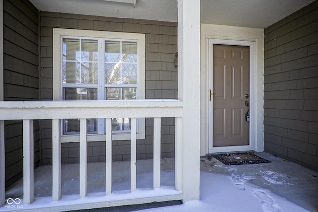 view of exterior entry featuring covered porch