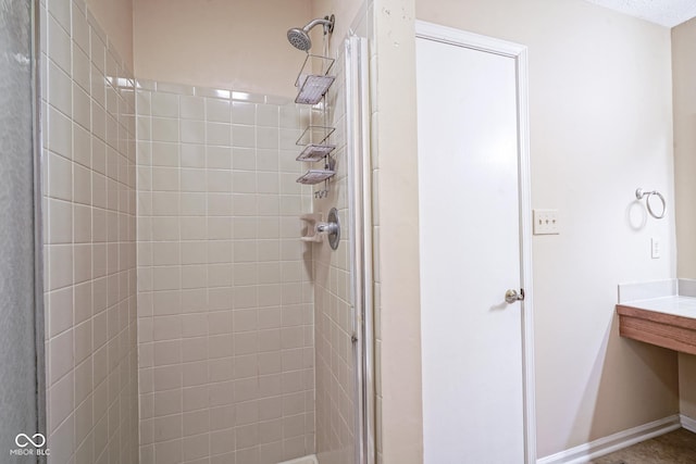 bathroom with a shower stall and baseboards