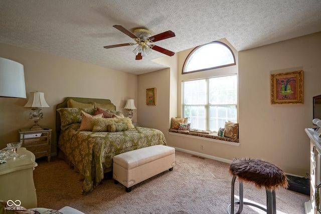 carpeted bedroom featuring baseboards, ceiling fan, visible vents, and a textured ceiling