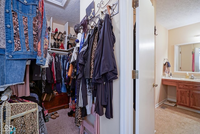 walk in closet featuring light colored carpet