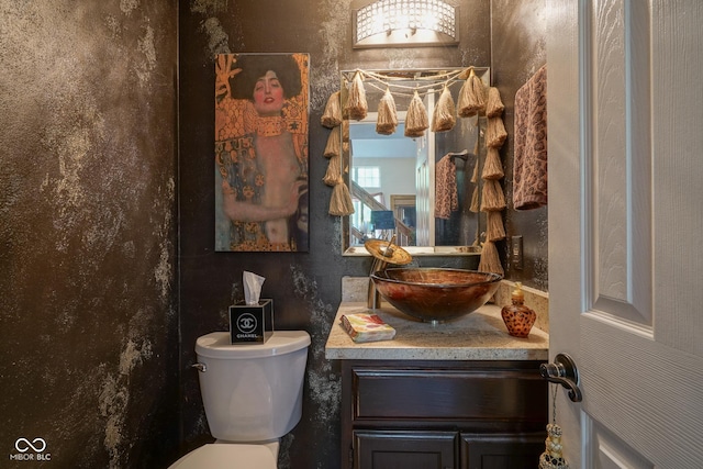 half bathroom with toilet and vanity