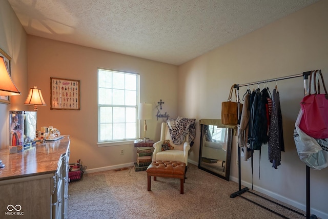 living area featuring baseboards, a textured ceiling, visible vents, and light colored carpet