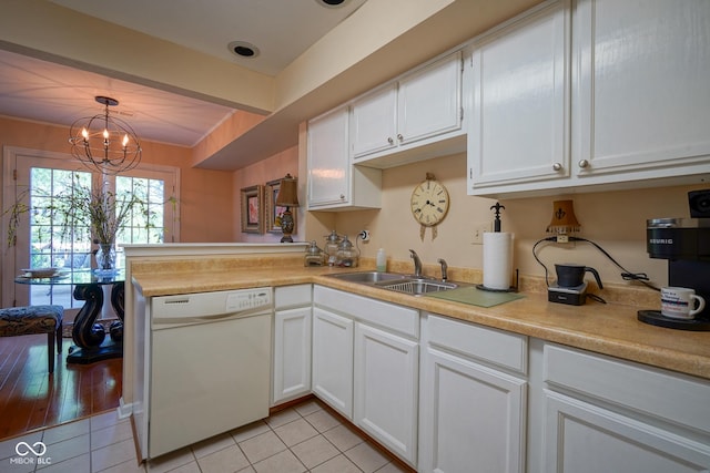 kitchen featuring a sink, white cabinetry, light countertops, dishwasher, and decorative light fixtures