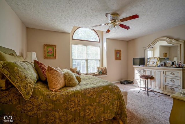 bedroom with light carpet, a ceiling fan, and a textured ceiling