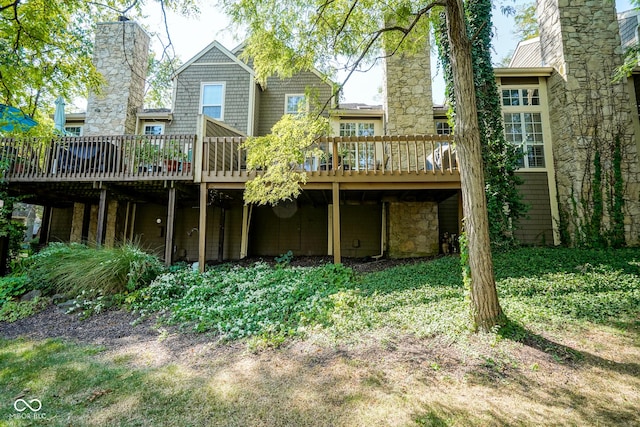 back of house featuring a chimney and a wooden deck