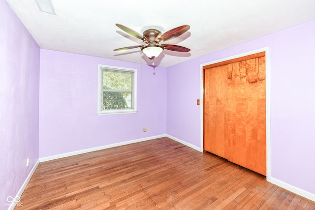 unfurnished bedroom featuring ceiling fan, light hardwood / wood-style flooring, and a closet