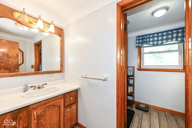 bathroom featuring wood-type flooring, vanity, and a textured ceiling